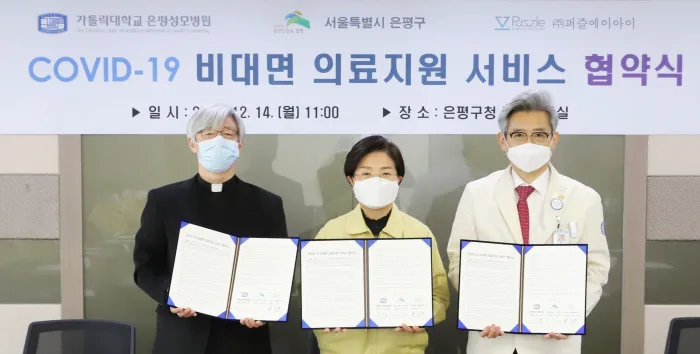 Three key figures pose for a photo during the signing ceremony for the COVID-19 non-face-to-face medical support service agreement. They are at the Eunpyeong District Office on August 14, wearing masks, and holding signed agreements.