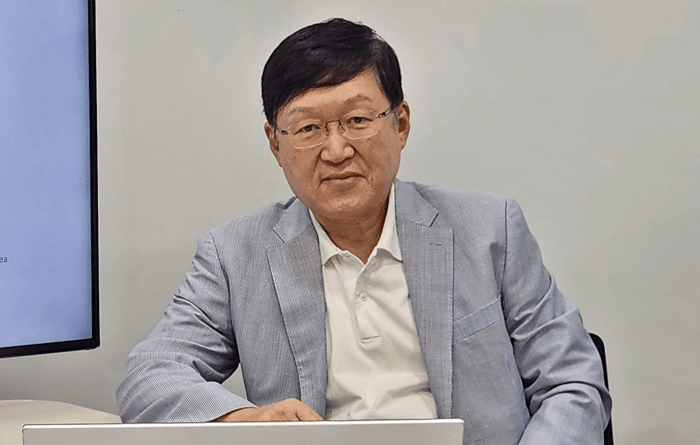 Kim Yong-sik, CEO of PuzzleAI, confidently smiling while seated at his desk, representing the forefront of innovation in digital health solutions.